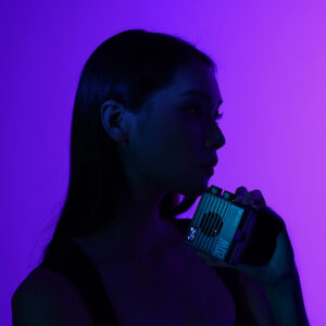 Ulanzi LE20 RGB video light producing vibrant purple and magenta lighting effects on a portrait subject, showcasing 360-degree full color HSI mode