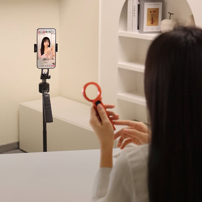 Tracking selfie stick with tripod for hands-free recording.