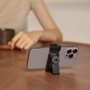 Ulanzi TT23 phone clamp used as compact tabletop phone stand holding an iPhone on a wooden desk for video calls and content viewing